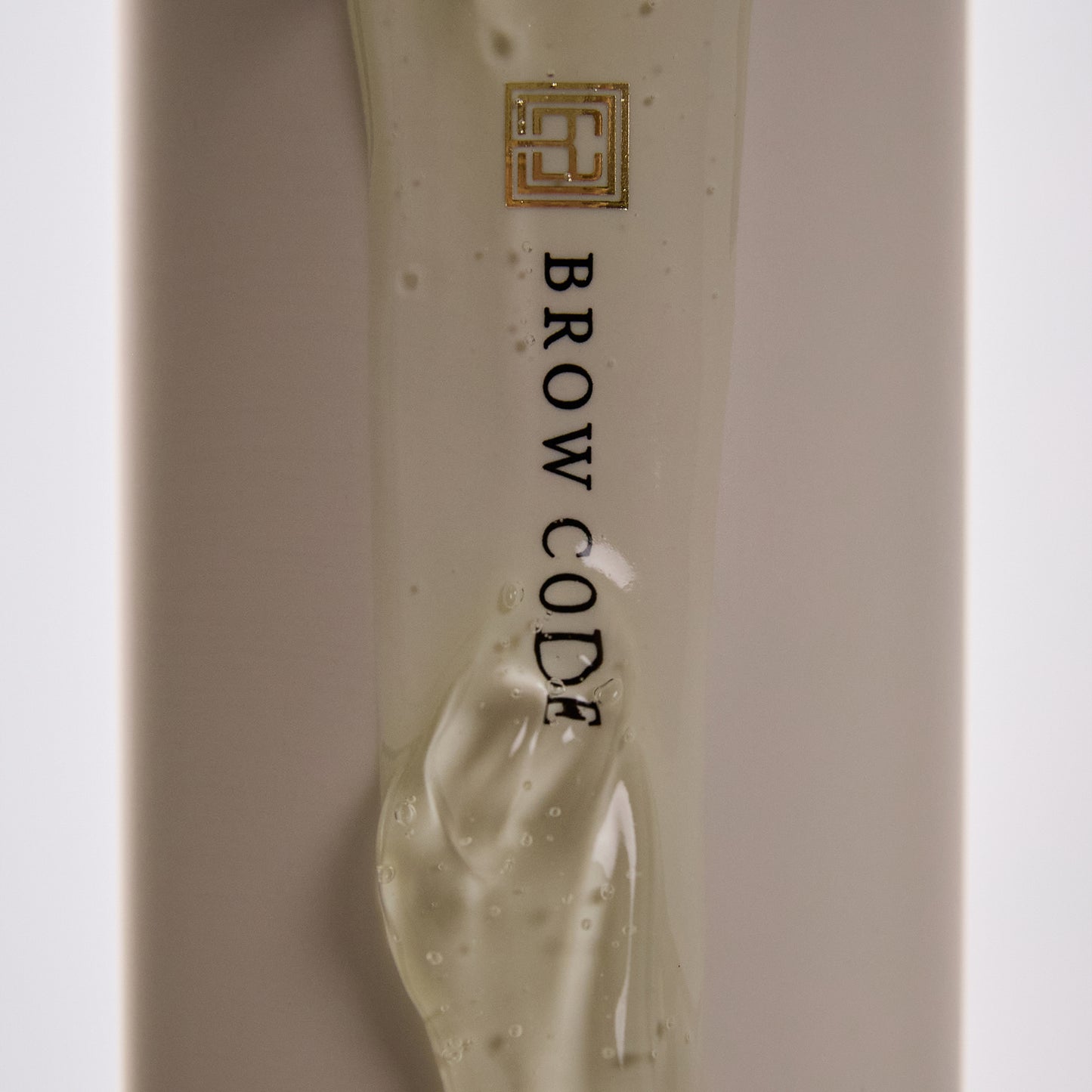 Close-up of Brow Code Arch Aid Renewal Gel texture flowing down the product packaging