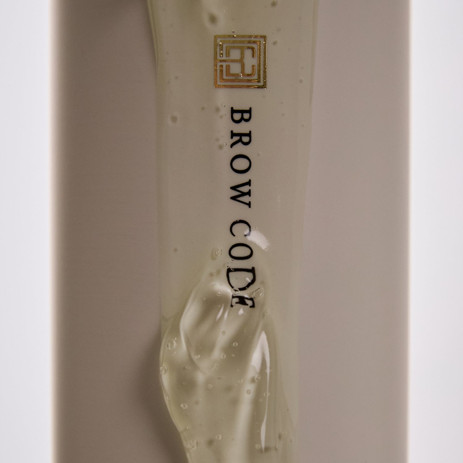 Close-up of Brow Code Arch Aid Renewal Gel texture flowing down the product packaging
