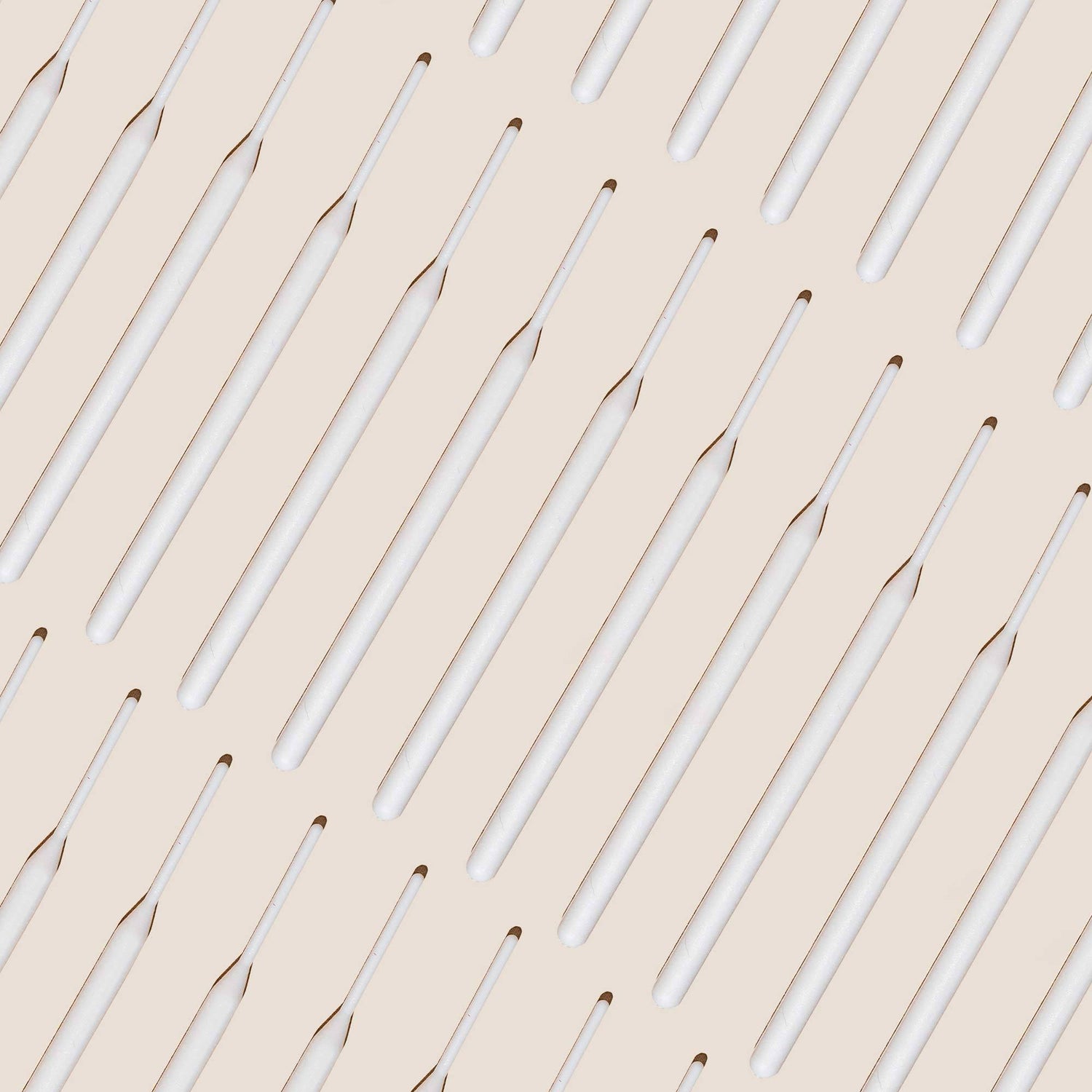 Numerous tinting sticks laid out against an off white background